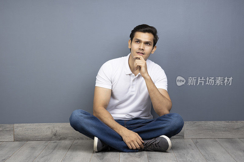 男人盘腿坐在地板上的stock photo